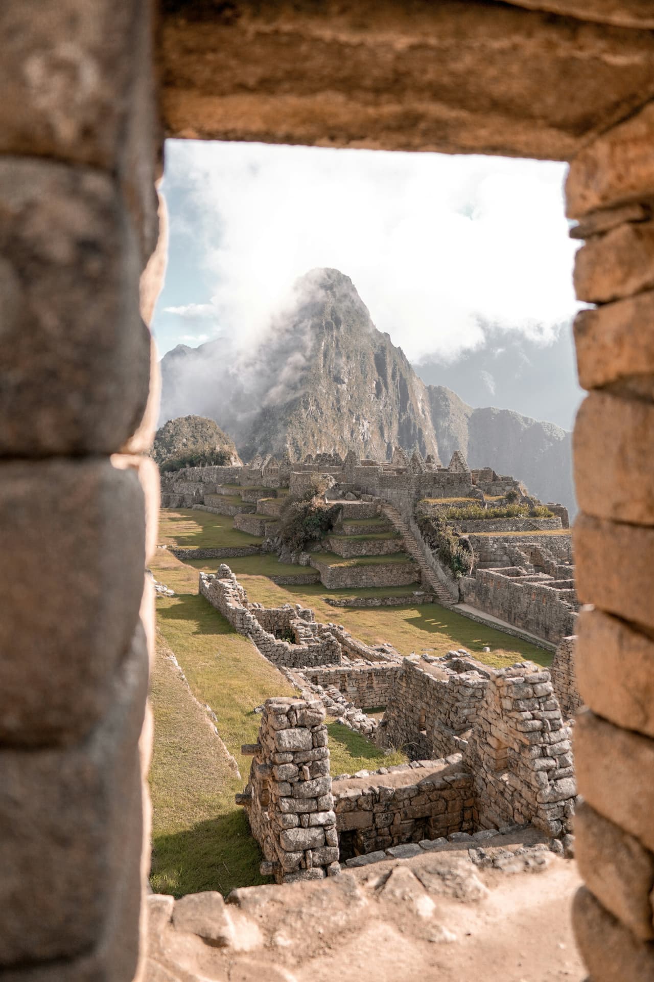 Doorkijk door een Inca-stenen venster op Machu Picchu, Peru